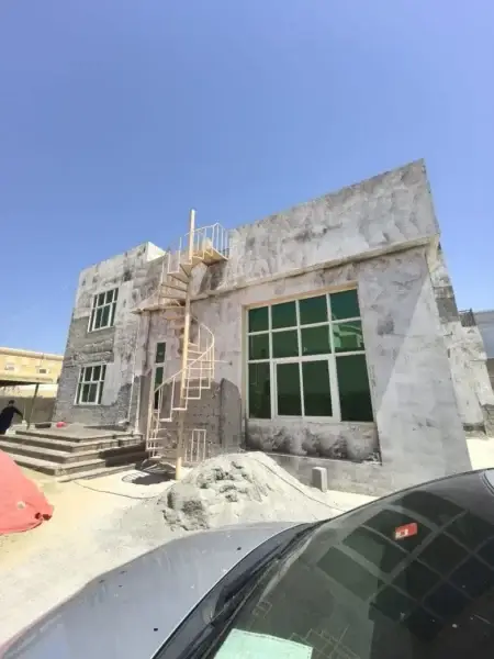 Construction Site of a Modern Building with a Spiral Staircase and Large Glass Windows