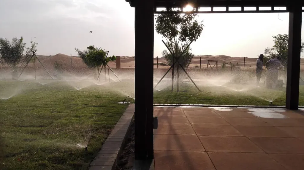 Landscape irrigation system watering the garden with automatic sprinklers in a residential area.