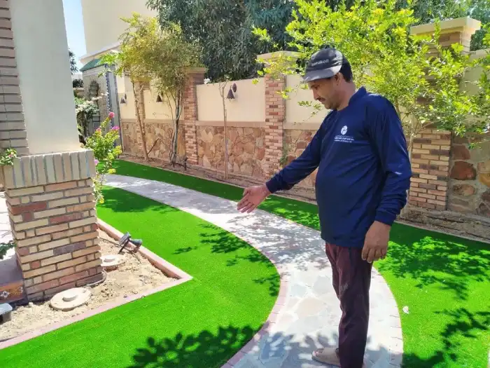 Flowers Yard supervisor inspecting completed artificial grass lawn installation at a Jumeirah villa in Dubai