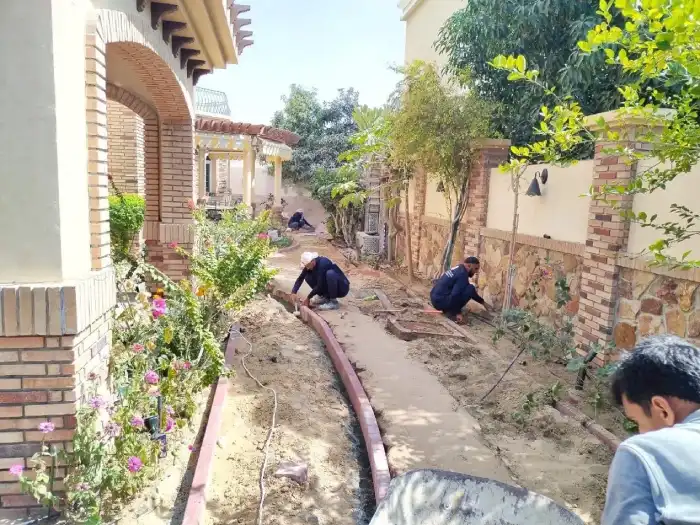 Flowers Yard team installing curved brick border edging along a villa garden pathway in Dubai